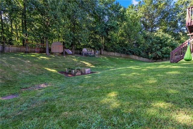 view of yard with an outdoor structure, a fenced backyard, and a storage unit