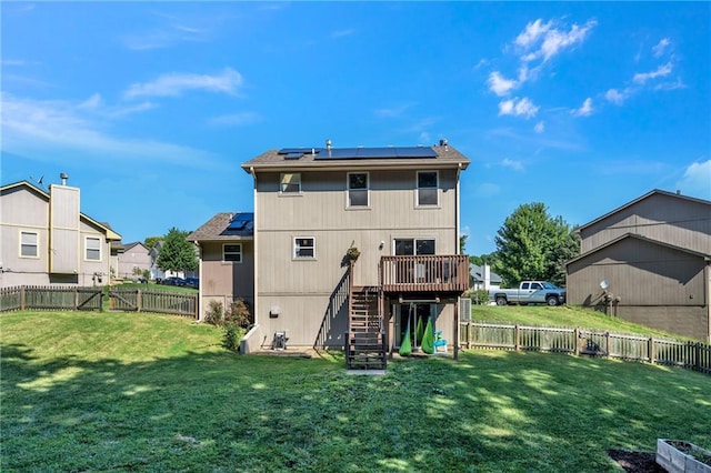 rear view of property featuring a fenced backyard, a deck, stairway, and a yard