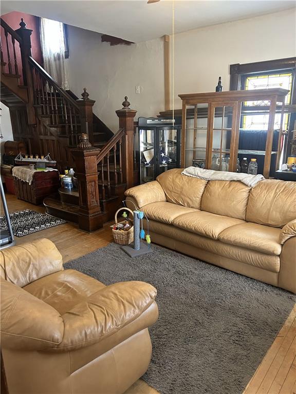 living room with wood finished floors and stairway