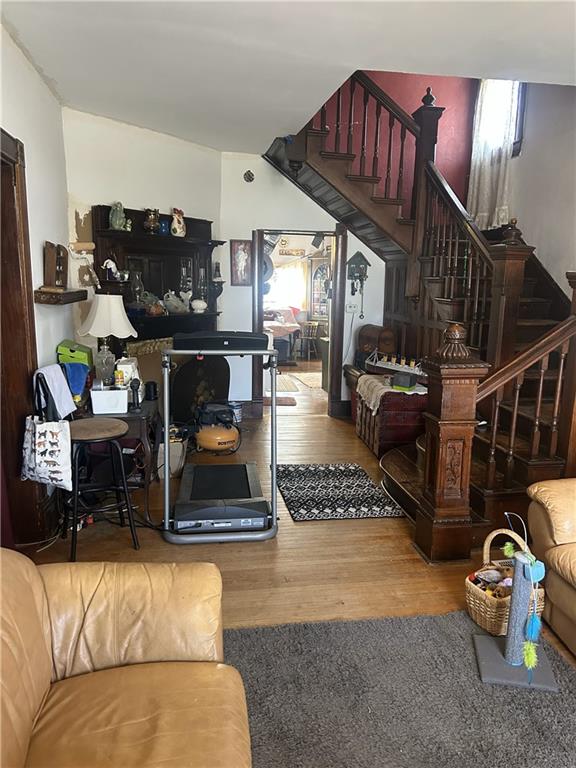 living area with stairs and wood finished floors
