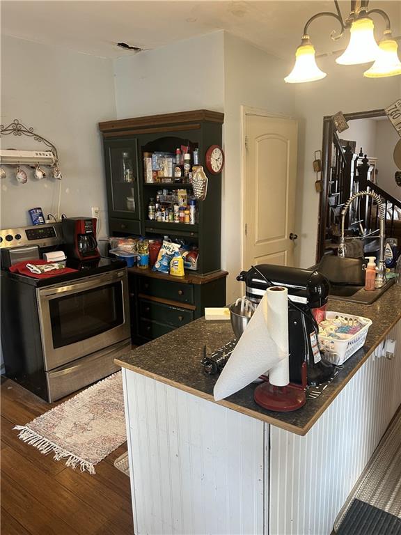 kitchen featuring dark countertops, wood finished floors, and stainless steel range with electric stovetop