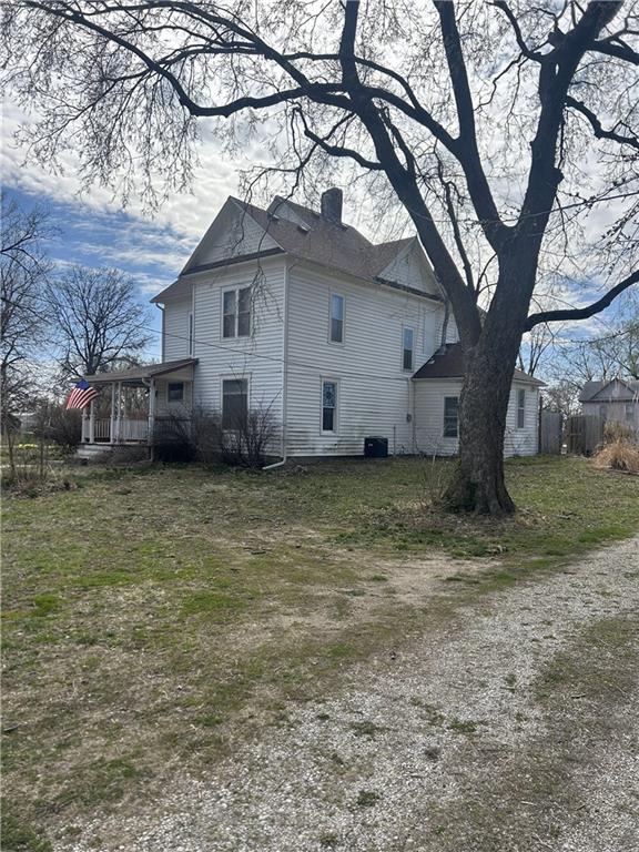 view of side of home featuring a chimney and central air condition unit