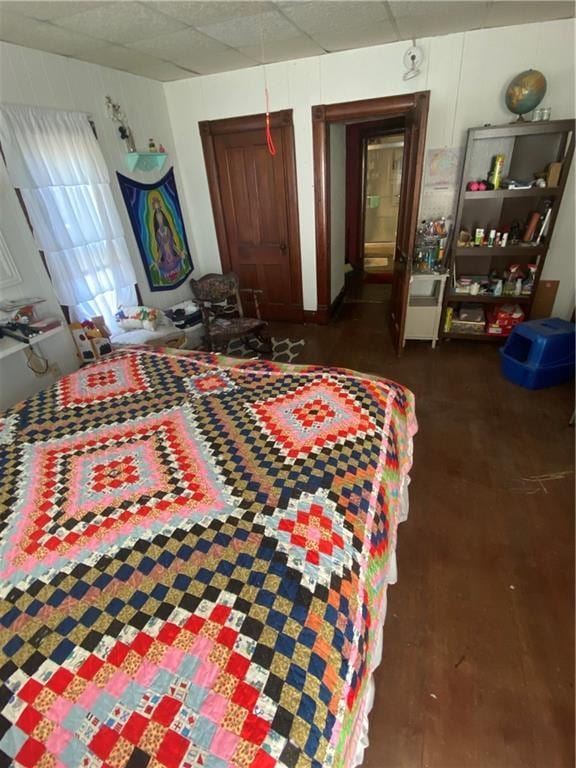 bedroom with wood finished floors and a paneled ceiling