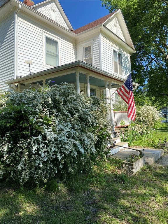 104 E Warren St, Williamsburg, KS 66095 - view of side of property with covered porch and a chimney