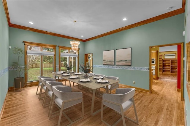 dining room with baseboards, a chandelier, ornamental molding, and light wood-style flooring