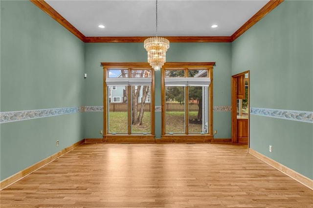 unfurnished room with crown molding, baseboards, an inviting chandelier, and wood finished floors