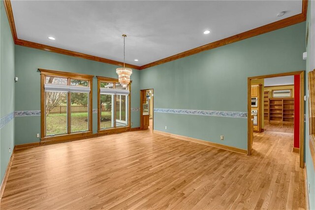 empty room featuring baseboards, a notable chandelier, ornamental molding, and light wood finished floors