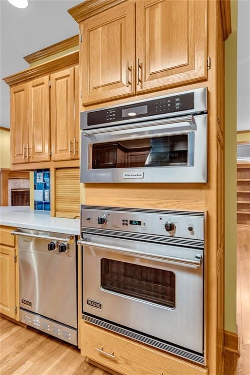 kitchen with light countertops, appliances with stainless steel finishes, and light wood finished floors