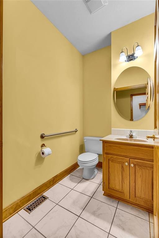 bathroom featuring visible vents, baseboards, toilet, and vanity