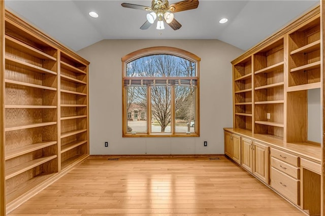 unfurnished office with baseboards, ceiling fan, light wood-style flooring, and lofted ceiling