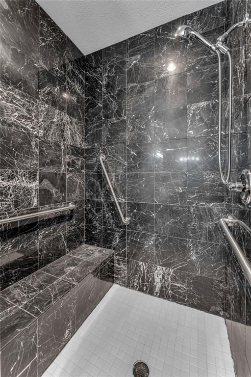full bath with a textured ceiling and tiled shower