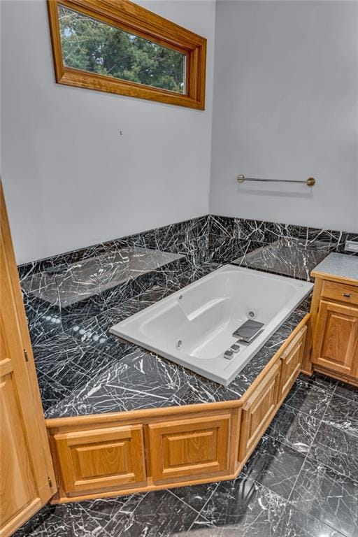 full bathroom with a whirlpool tub and marble finish floor