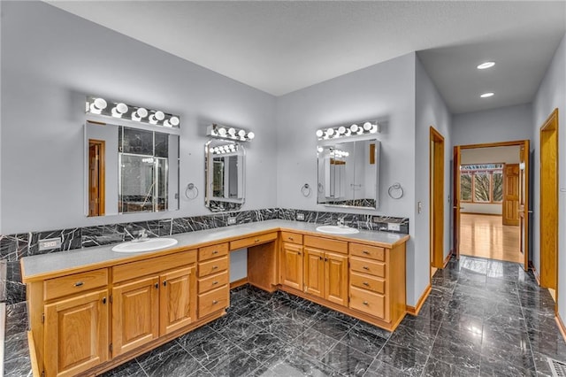 bathroom featuring a sink, a shower stall, double vanity, and marble finish floor