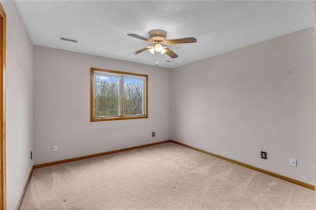 carpeted empty room with a ceiling fan, baseboards, and visible vents