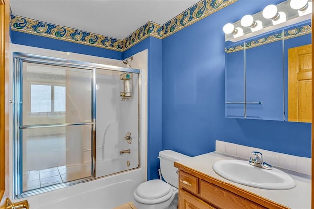 bathroom with toilet, shower / bath combination with glass door, and vanity