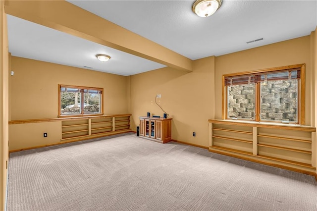 spare room with carpet floors, baseboards, and visible vents
