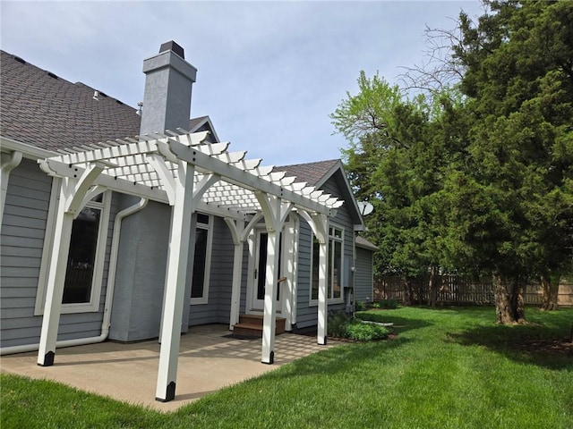rear view of property featuring a chimney, a lawn, a patio area, fence, and a pergola