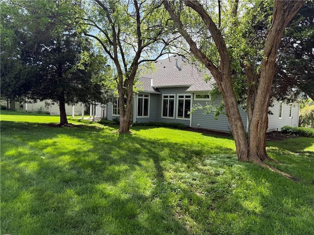 back of house with a lawn