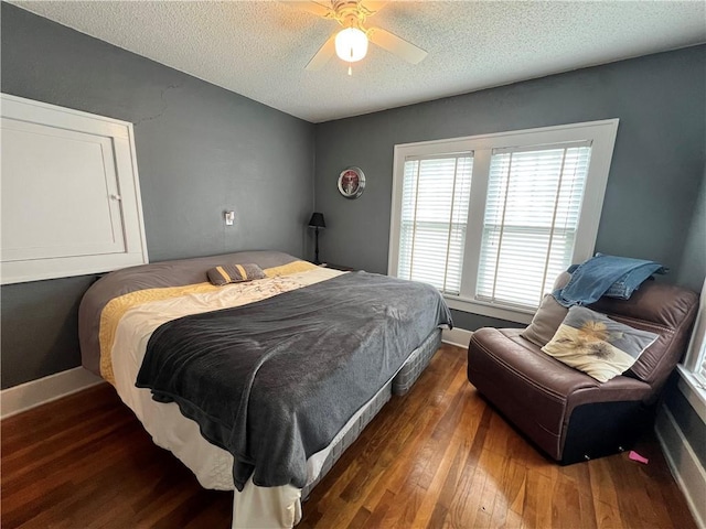 bedroom with hardwood / wood-style floors, a textured ceiling, baseboards, and ceiling fan