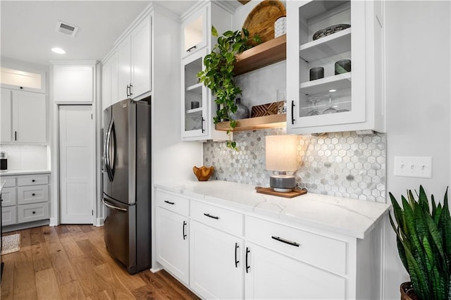 3208 SW Saddlebred Ter, Lees Summit, MO 64082 - kitchen featuring freestanding refrigerator, white cabinets, light stone countertops, wood finished floors, and recessed lighting
