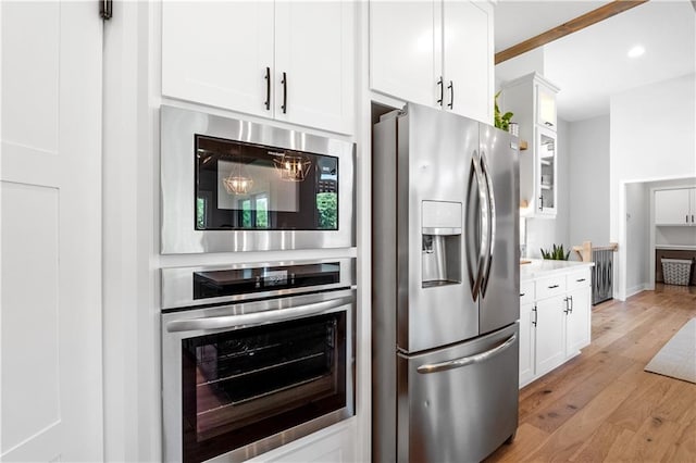 3208 SW Saddlebred Ter, Lees Summit, MO 64082 - kitchen with appliances with stainless steel finishes, white cabinetry, light wood finished floors, recessed lighting, and light countertops