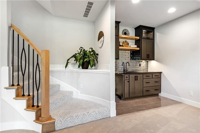 3208 SW Saddlebred Ter, Lees Summit, MO 64082 - bar with a sink, baseboards, stairway, decorative backsplash, and light colored carpet