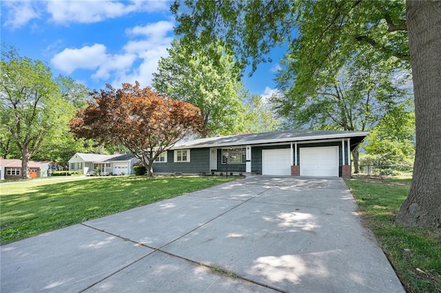 single story home featuring a garage, a front lawn, and concrete driveway