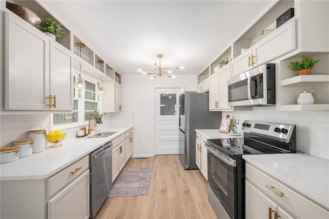 kitchen with appliances with stainless steel finishes, open shelves, a chandelier, and tasteful backsplash