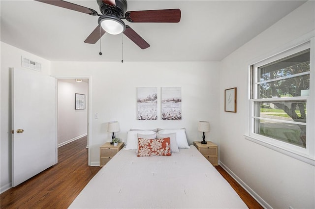 bedroom with dark wood-type flooring, baseboards, and ceiling fan