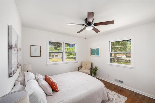 bedroom with baseboards, dark wood-type flooring, and a ceiling fan