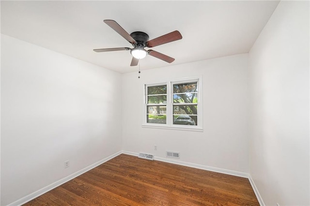 unfurnished room featuring baseboards, a ceiling fan, and dark wood-type flooring