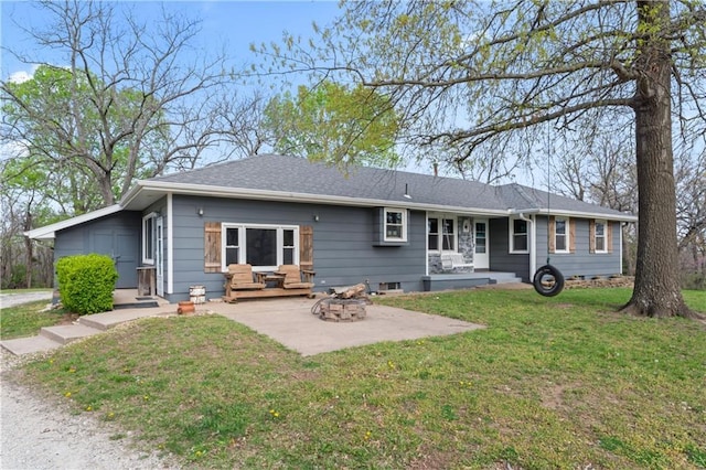 rear view of house featuring a yard, a fire pit, and a patio area