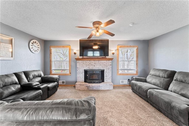 living area featuring a ceiling fan, a textured ceiling, visible vents, and carpet