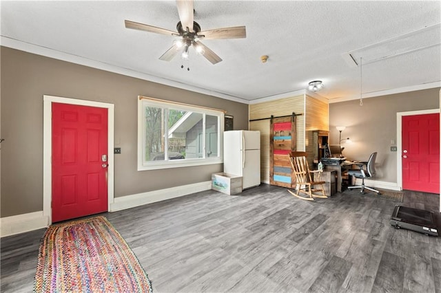 foyer entrance featuring crown molding, wood finished floors, baseboards, a textured ceiling, and a ceiling fan