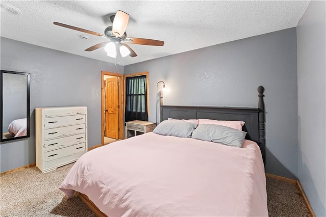 carpeted bedroom with a textured ceiling, baseboards, and ceiling fan