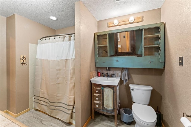 bathroom featuring a textured ceiling, a textured wall, and toilet