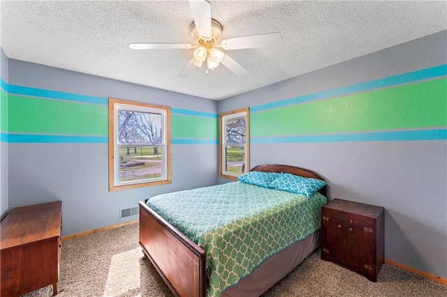 bedroom featuring carpet flooring, a textured ceiling, a ceiling fan, baseboards, and visible vents