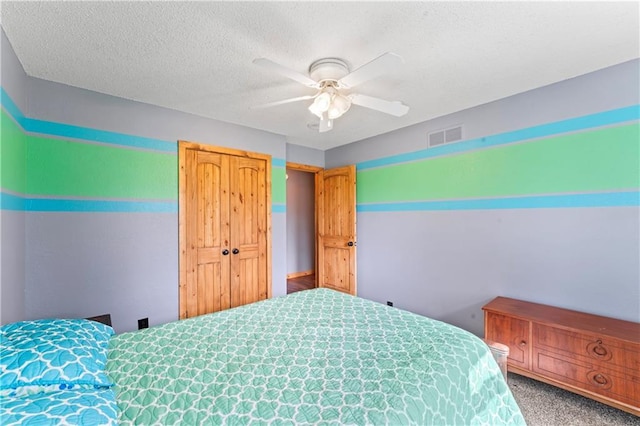bedroom with carpet floors, ceiling fan, a textured ceiling, and visible vents