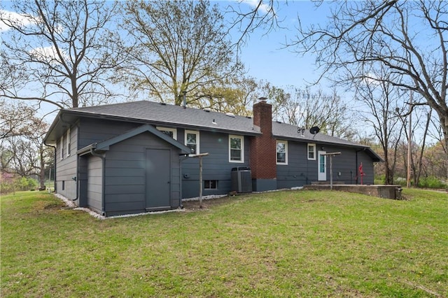 rear view of property with a lawn, cooling unit, and a chimney