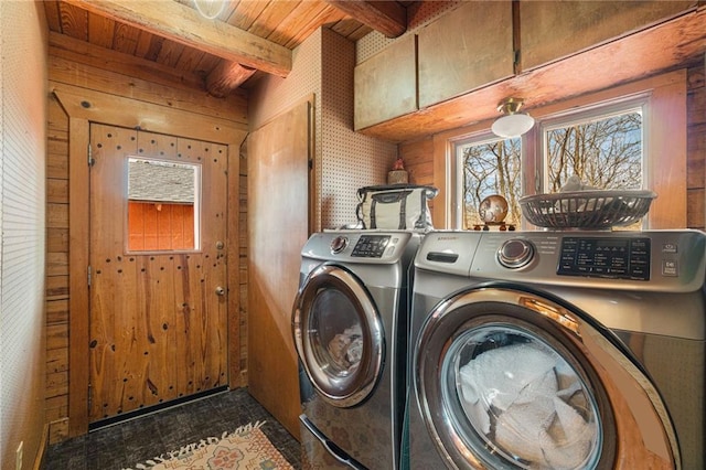 laundry area featuring wood walls, laundry area, separate washer and dryer, and wood ceiling