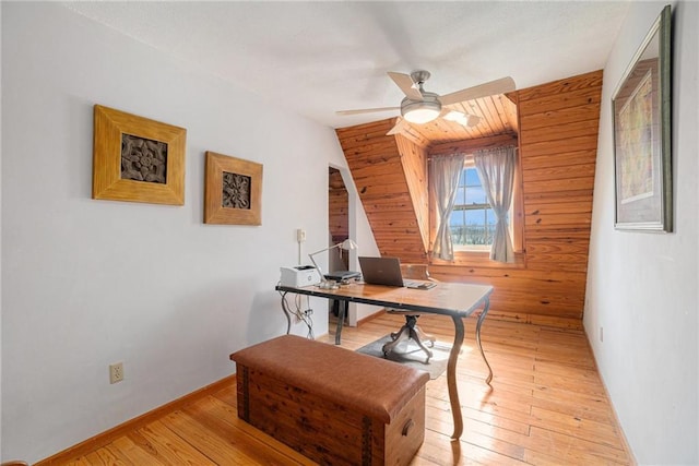 home office with ceiling fan, wood walls, and light wood-style floors