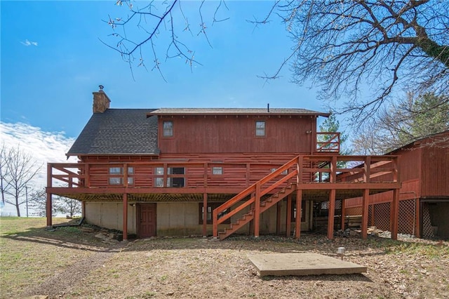 back of property with a chimney, a deck, stairs, and dirt driveway