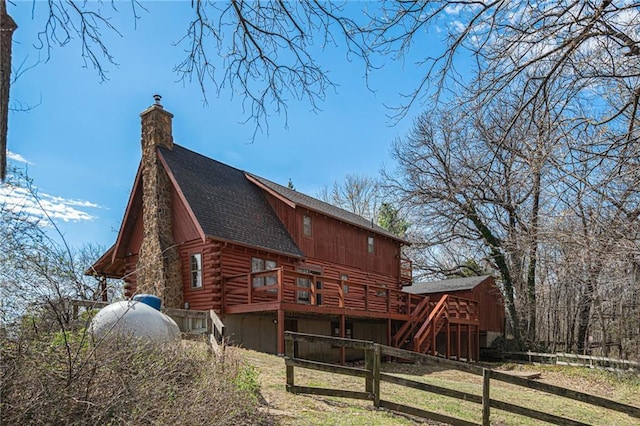 back of house featuring stairway, log siding, a deck, fence, and a shingled roof