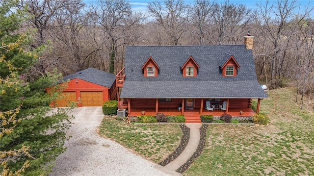 chalet / cabin featuring an outdoor structure, central AC unit, covered porch, a garage, and a chimney