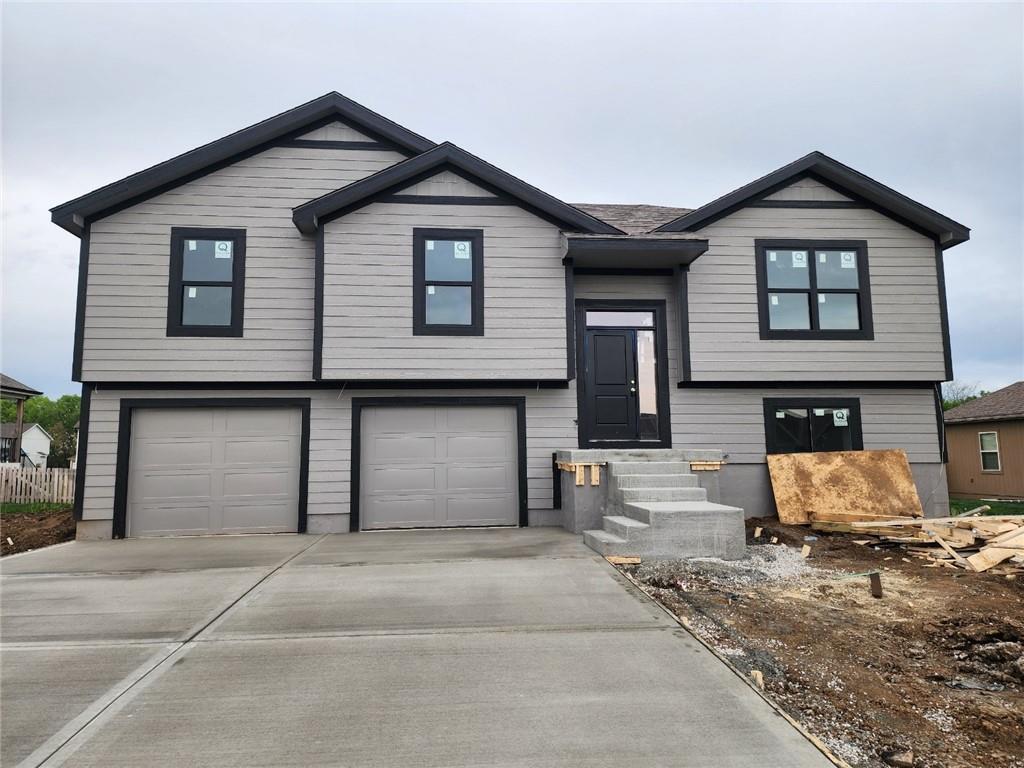 split foyer home with a garage, driveway, and entry steps