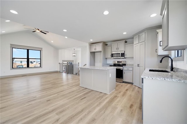815 W Solomon Dr, Lone Jack, MO 64086 - kitchen with a sink, stainless steel appliances, light wood-style floors, light stone countertops, and lofted ceiling
