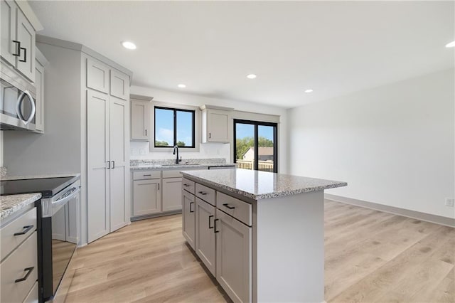 815 W Solomon Dr, Lone Jack, MO 64086 - kitchen with range with electric stovetop, stainless steel microwave, gray cabinets, a center island, and a sink