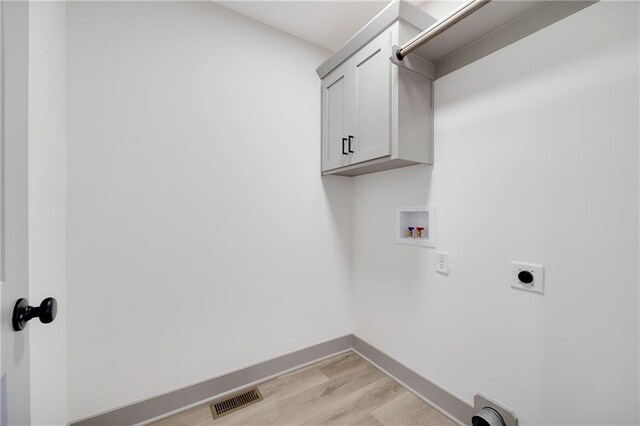 815 W Solomon Dr, Lone Jack, MO 64086 - laundry area featuring electric dryer hookup, light wood finished floors, cabinet space, washer hookup, and baseboards