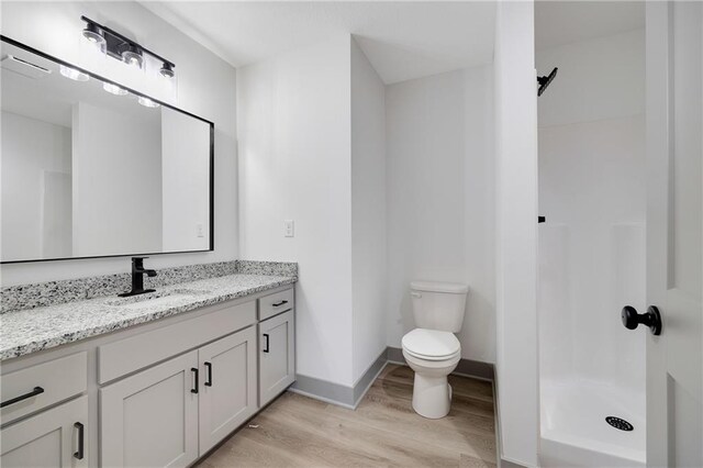 815 W Solomon Dr, Lone Jack, MO 64086 - full bathroom featuring wood finished floors, vanity, a shower, toilet, and baseboards