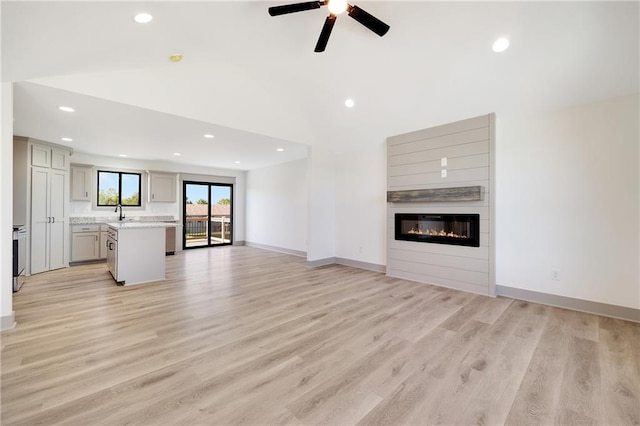 815 W Solomon Dr, Lone Jack, MO 64086 - unfurnished living room with vaulted ceiling, a fireplace, ceiling fan, recessed lighting, and light wood-style flooring
